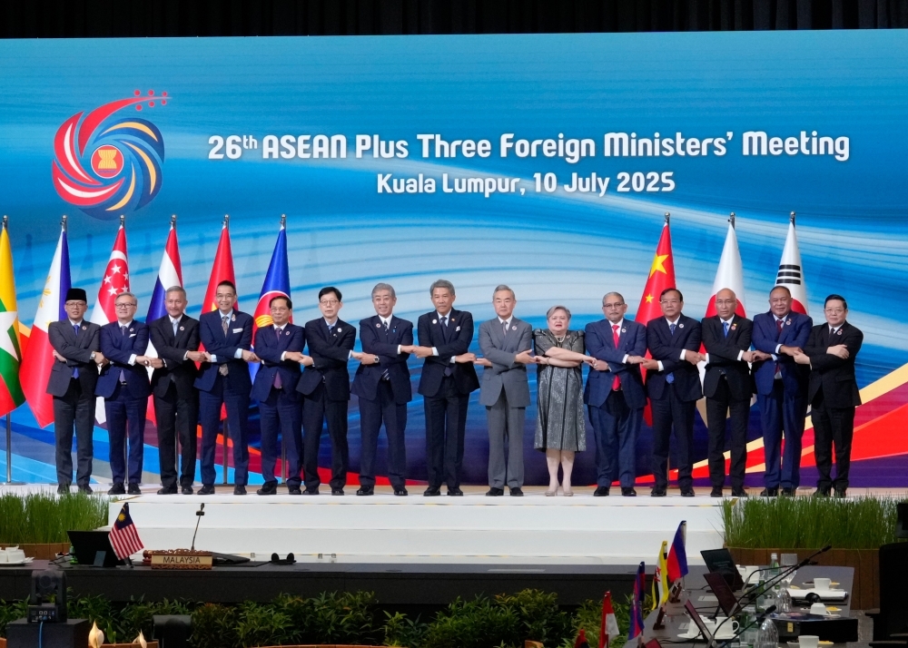 ASEAN Plus3 Foreign Ministers on the stage shaking hands with each other