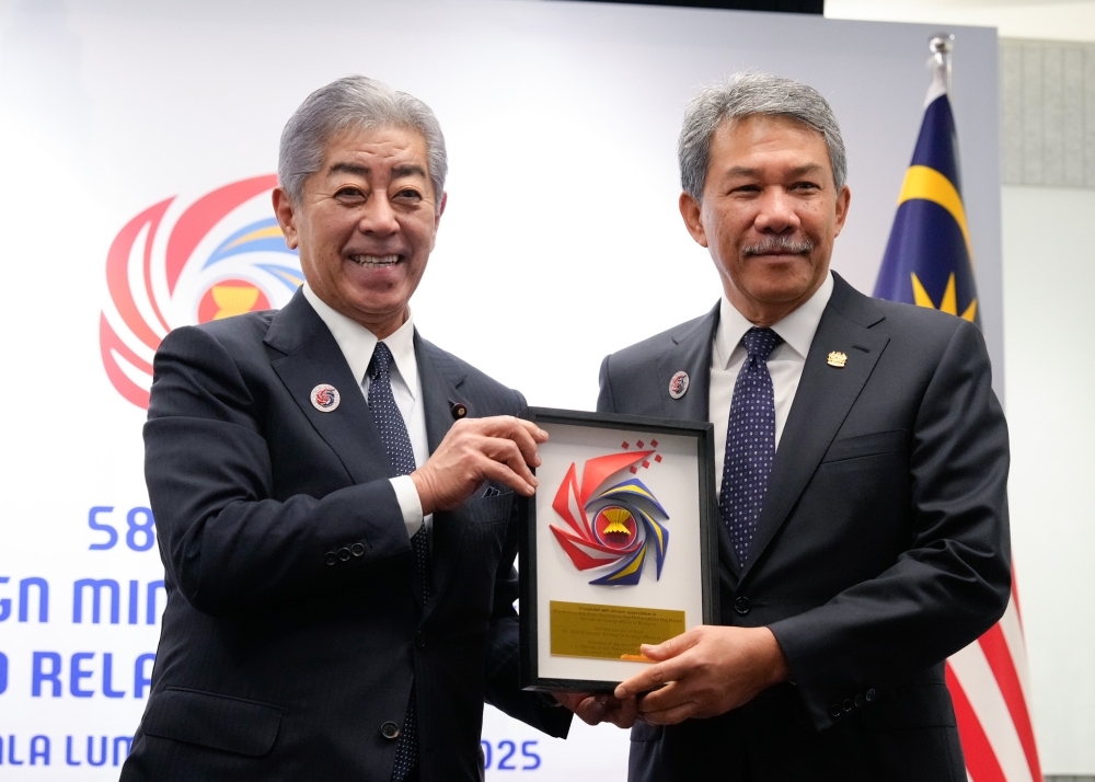 Foreign Minister Iwaya is handing over an origami artwork crafted by the Malaysia Origami Academy, depicting the logo of the ASEAN Chairmanship Year, to Dato' Seri Utama Haji Mohamad bin Haji Hasan, Minister of Foreign Affairs of Malaysia