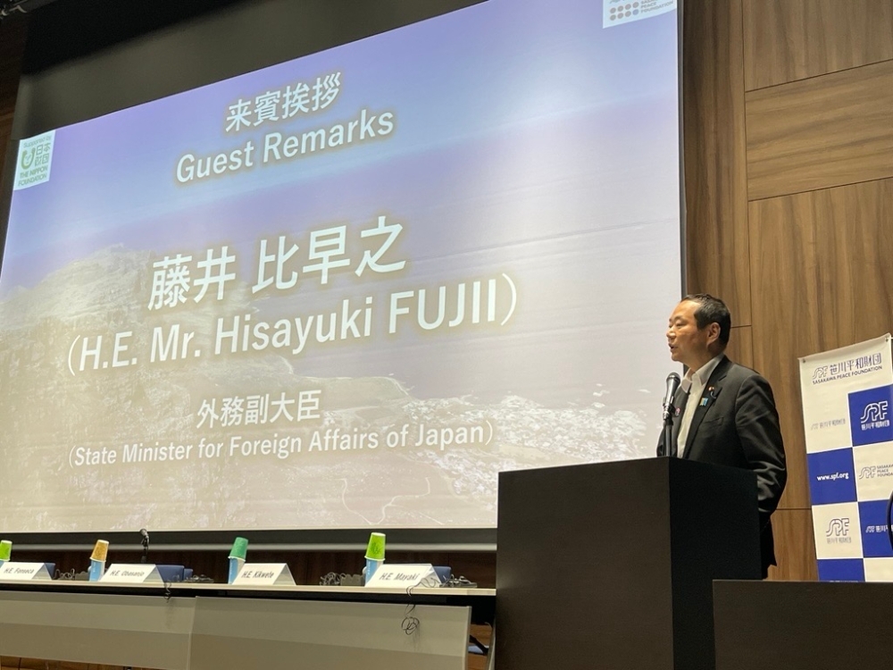 State Minister Fujii giving a Guest Speech on the Stage at the symposium