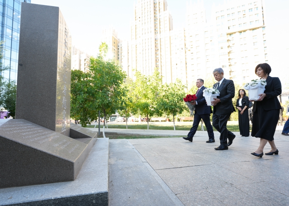 Minister IWAYA, Mrs. IWAYA and with Minister Nurtleu laying flowers at the memorial monument for Japanese victims