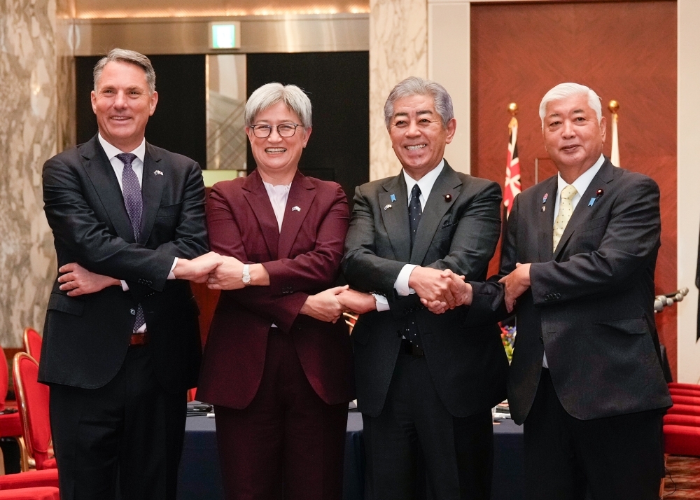 Minister IWAYA and Minister NAKATANI taking hands crossing their arms with the Hon. Richard Marles MP, Deputy Prime Minister and Minister for Defence of the Commonwealth of Australia and Senator the Hon. Penny Wong, Minister for Foreign Affairs of the Commonwealth of Australia in Tokyo