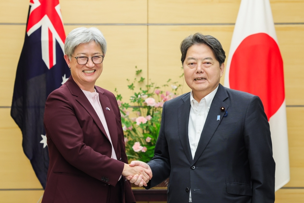 Chief Cabinet Secretary HAYASHI shaking hands with Foreign Minister Wong