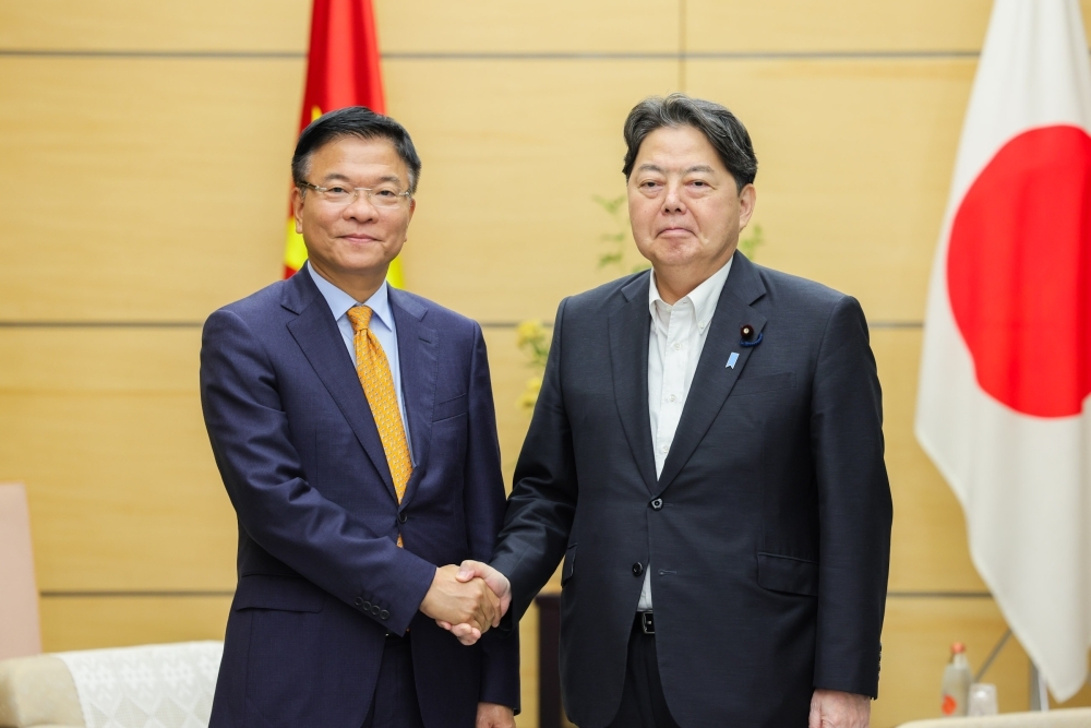 Chief Cabinet Secretary HAYASHI shaking hands with Deputy Prime Minister Long