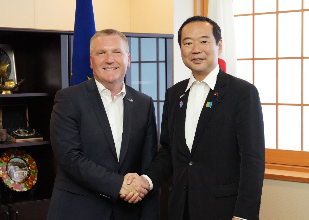 State Minister Fujii shaking hands with Commissioner McGrath