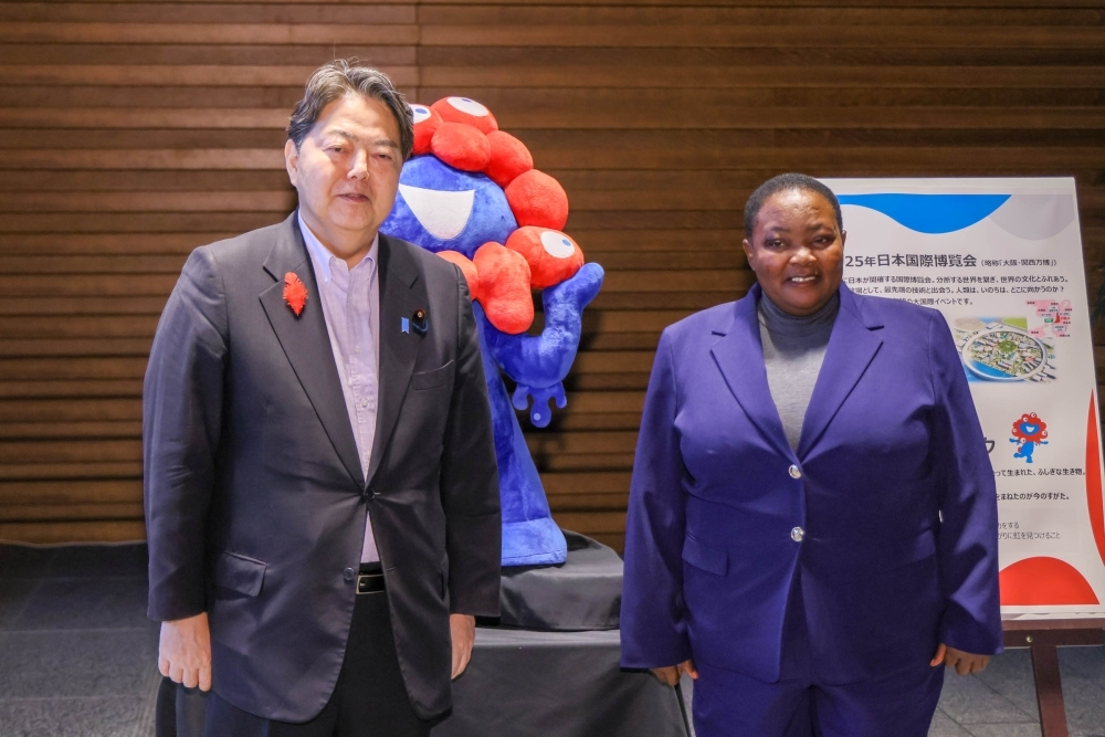 Chief Cabinet Secretary HAYASHI and Rt. Hon. Nabbanja, Prime Minister of Uganda, in front of the Expo Character MYAKU-MYAKU