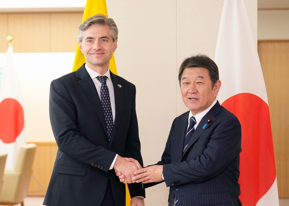 Minister MOTEGI shaking hands with Minister Budrys