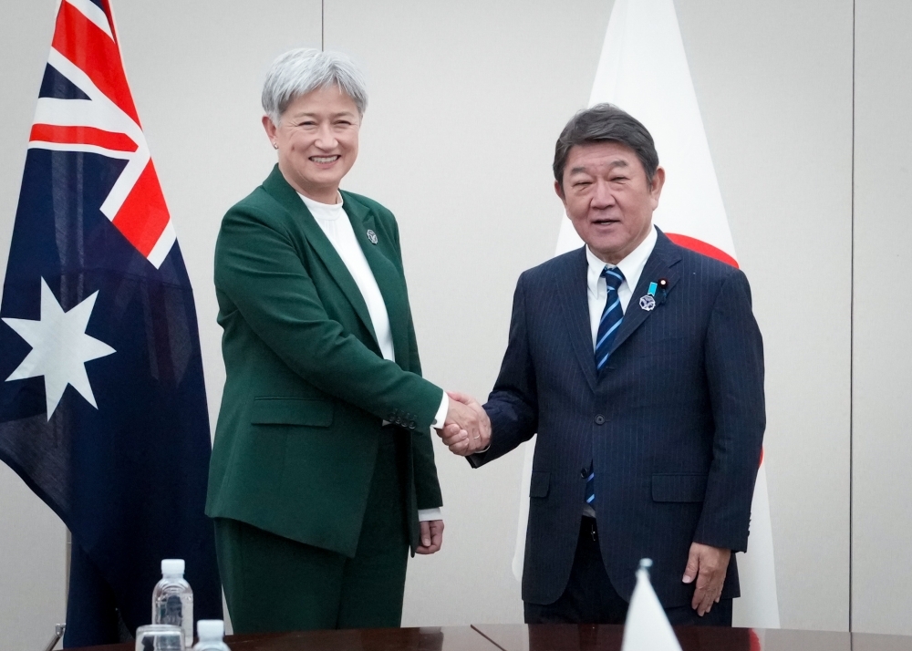 Foreign Minister MOTEGI shaking hands with Minister Wong
