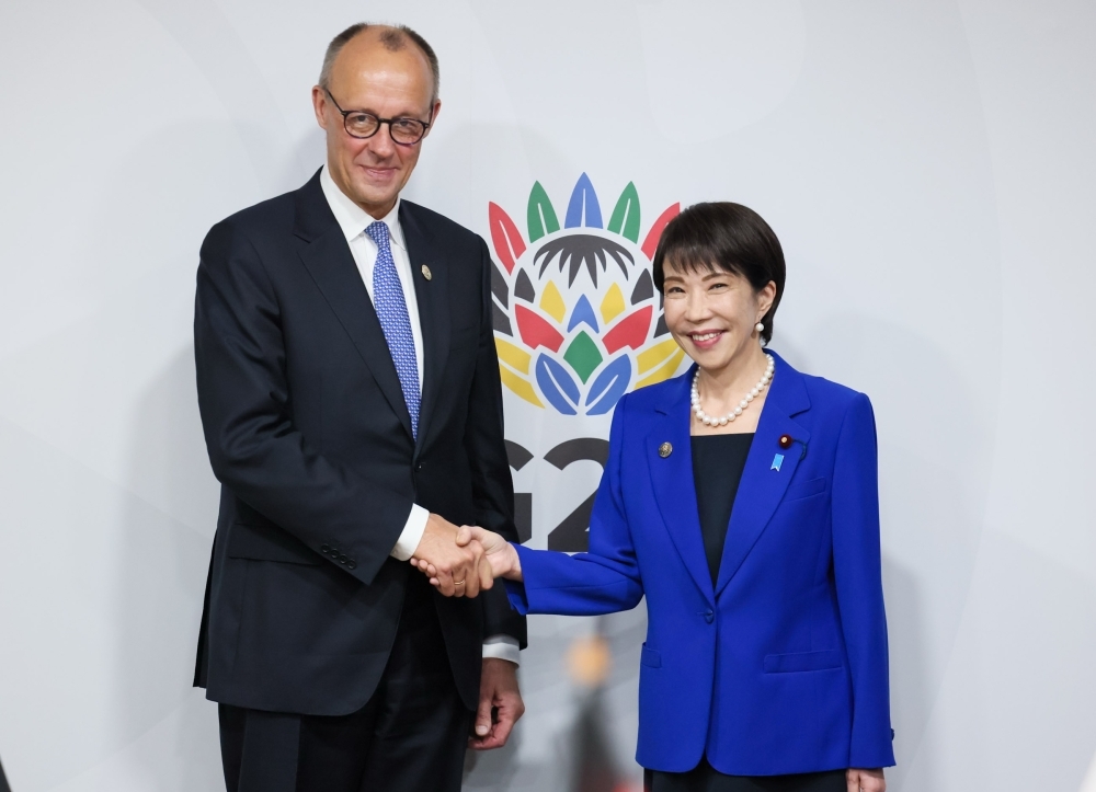 Prime Minister Takaichi shaking hands with Chancellor Merz
