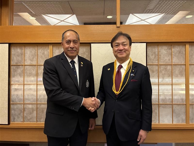 State Minister Horii shaking hands with Prime Minister Tagelagi