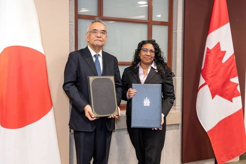 Ambassador Yamanouchi and Deputy Minister Curtis-Micallef taking a photo after signing the treaty