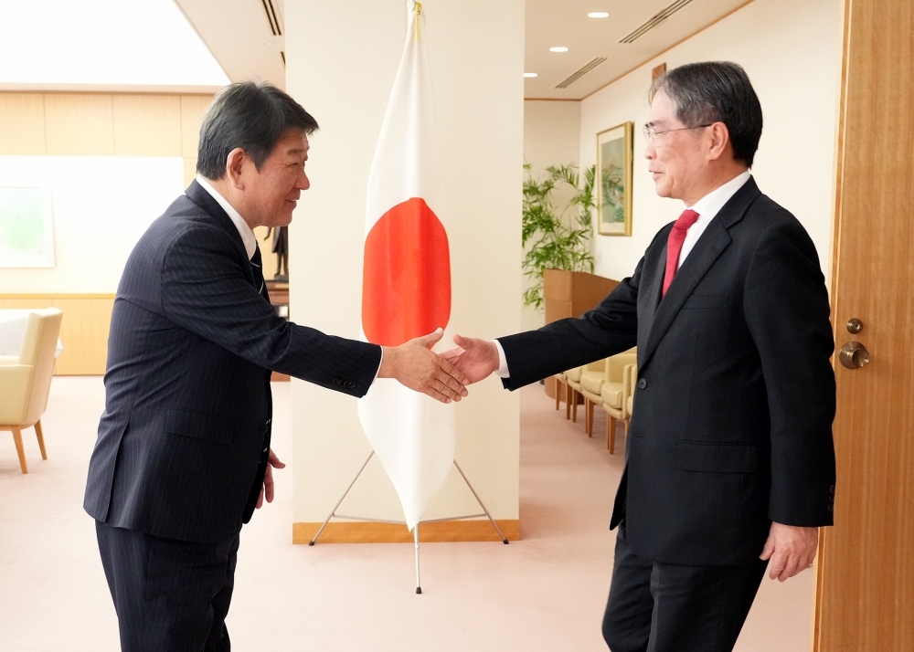 Foreign Minister MOTEGI is shaking hands with Judge Iwasawa, President of the International Court of Justice (ICJ)