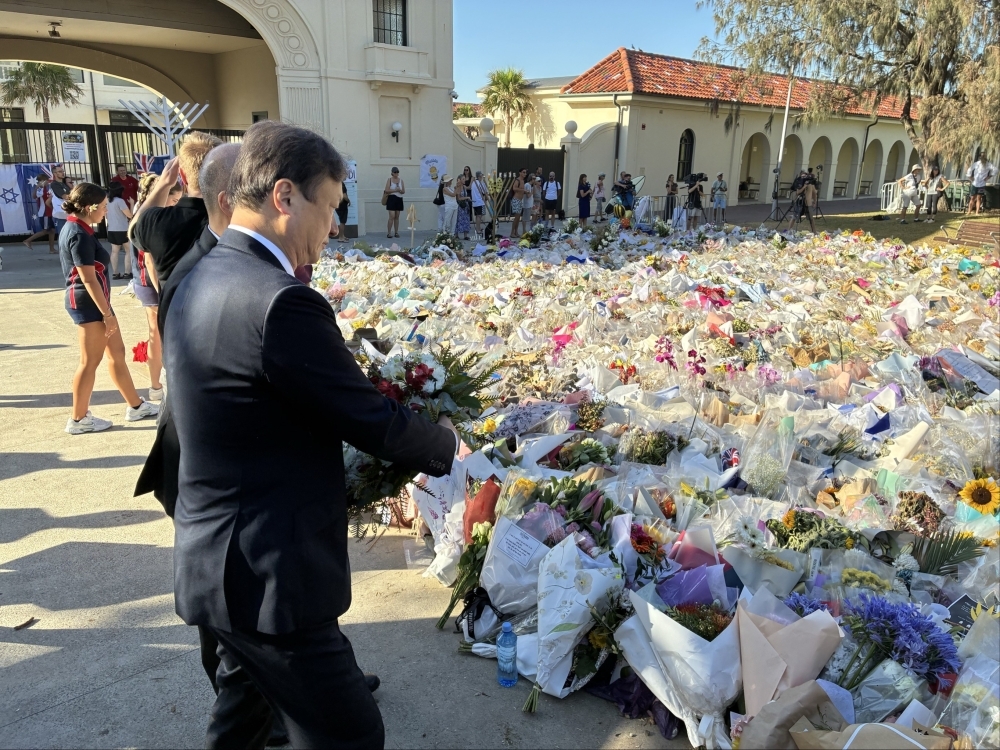 State Minister HORII offering flowers for and silent prayer at Bondi Beach, Sydney