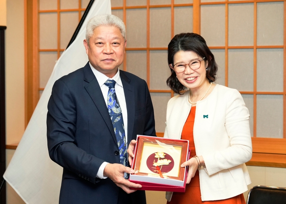 State Minister KUNIMITSU receiving a commemorative gift from H.E. Mr. Khuong, Deputy Minister of Home Affairs of Viet Nam