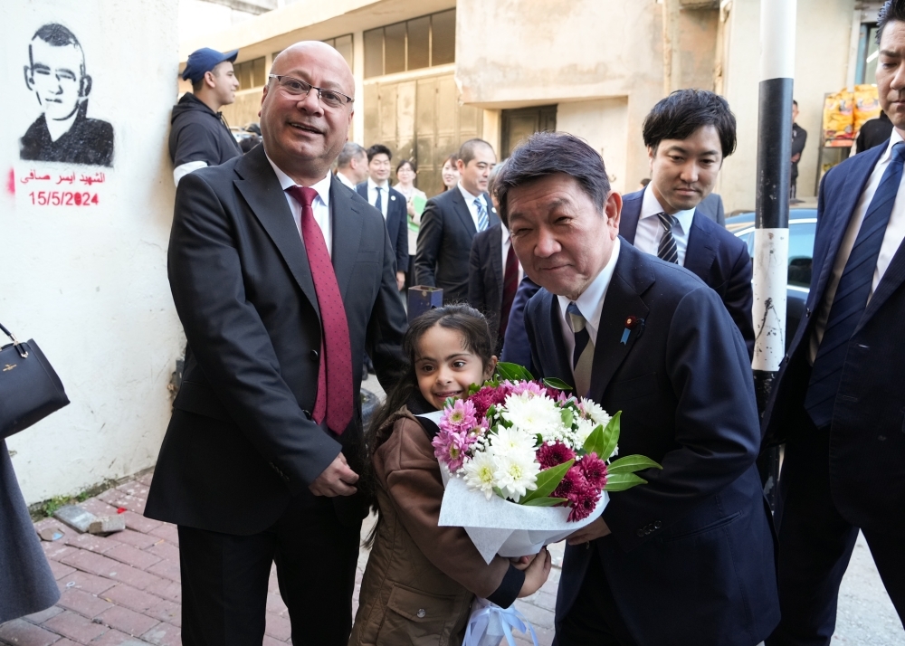Foreign Minister MOTEGI visits Jalazone refugee camp and receives a bouquet of flowers