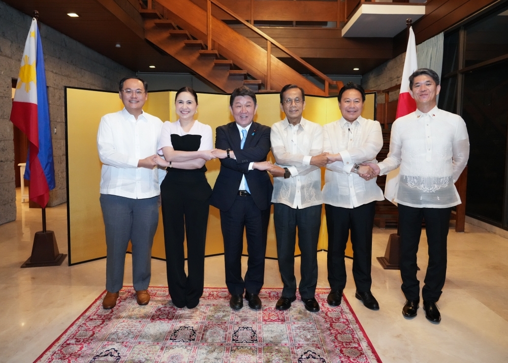 Minister Motegi holding hands with Philippine Ministers for photo session 