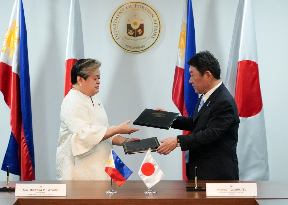 Both Foreign Minister MOTEGI and Hon. Maria Theresa Lazaro, Secretary of Foreign Affairs, exchanging signed documents