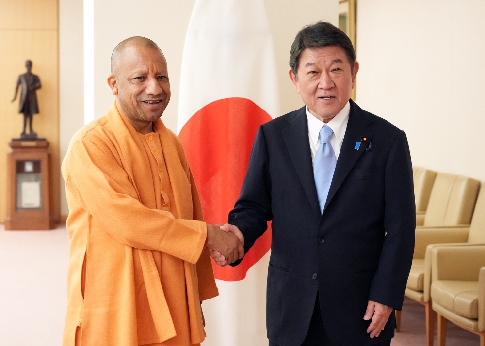 Foreign Minister Motegi shaking hands with Chief Minister Yogi