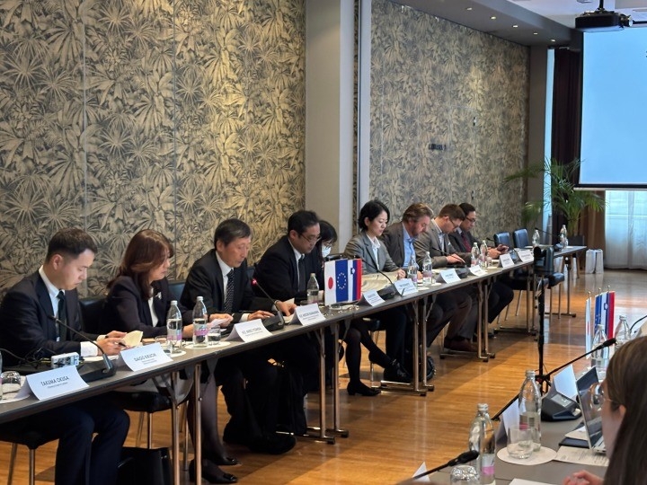 Japanese participants are seated in a row, participating in the discussion.