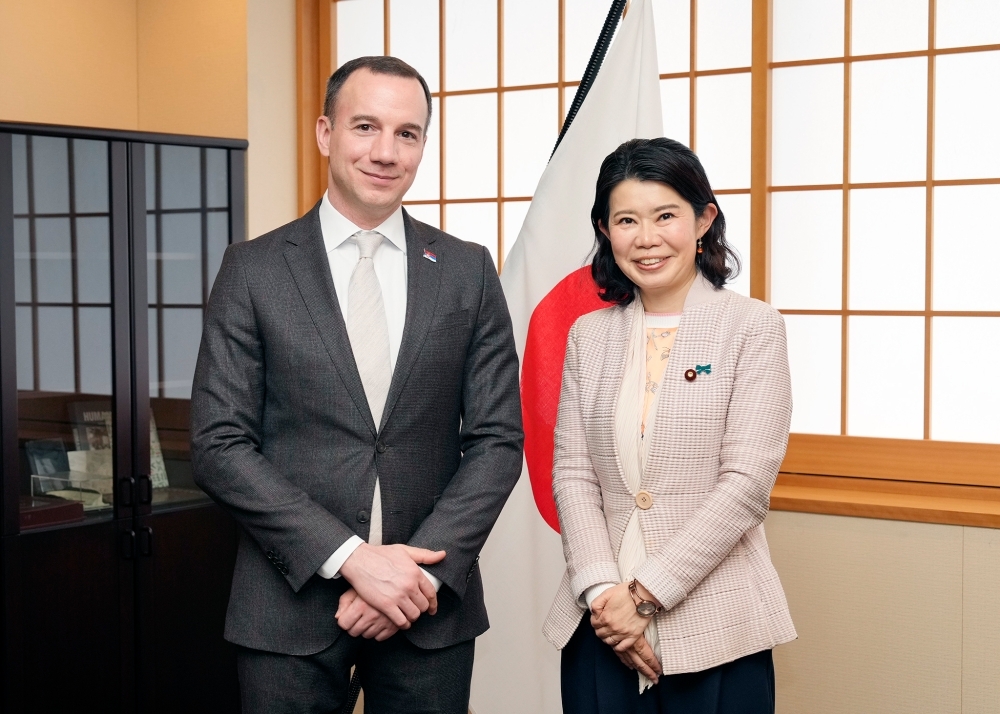 State Minister KUNIMITSU and Minister Jović standing in front of the Japanese flag
