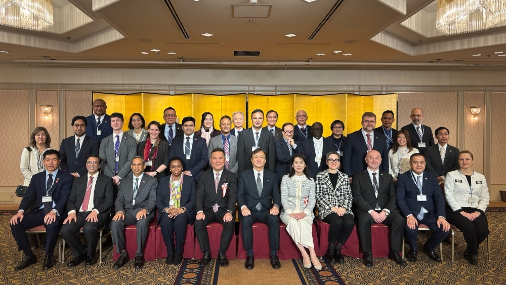 Group photo with participants lined up, centered around State Minister HORII  in the front row