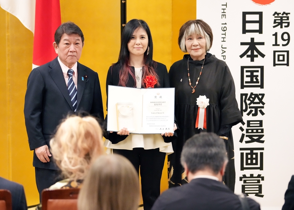 Group photo, Foreign Minister Motegi, Ms. Satonaka, chairperson of the selection committee and the Gold Award winner, Ms. Laica Chrose