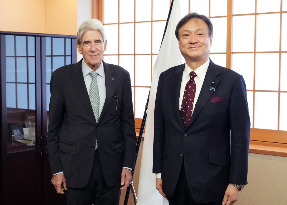 State Minister HORII and Chancellor Frenk standing side by side in front of the Japanese national flag