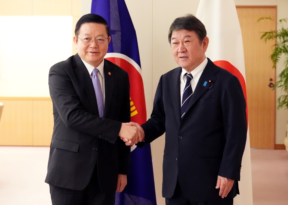 Minister MOTEGI shaking hands with Secretary-General Kao Kim Hourn