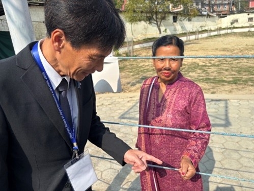 Parliamentary Vice-Minister Shimada receiving an explanation of the polling station facilities