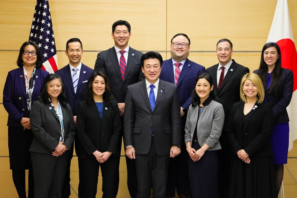 A close-up group photo of Japanese-American leaders standing in two rows, with Chief Cabinet Secretary KIHARA at the center of the front row
