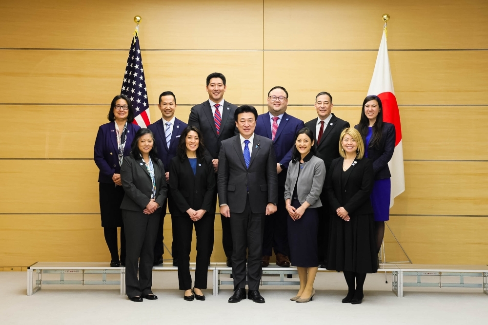 A wide-angle group photo showing the full figures of Chief Cabinet Secretary Kihara and a delegation of Japanese American leaders