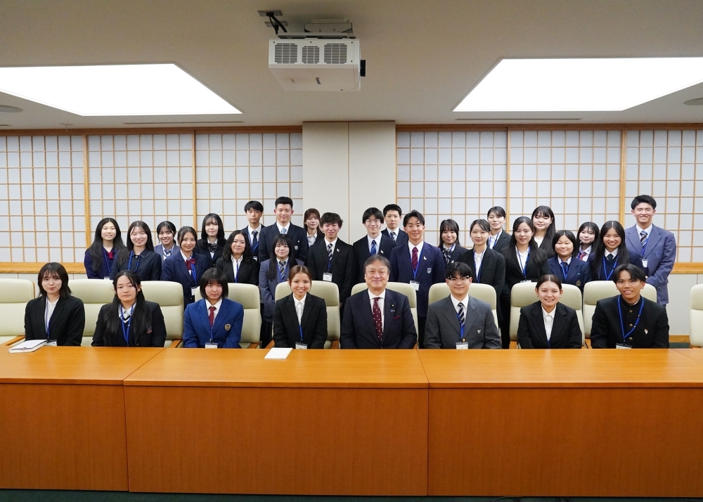 Group photo featuring State Minister HORII seated in the center of the front row, flanked by students participating in the program