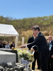 State Minister Horii pouring water over a stone monument at the Japan-U.S. Reunion of Honor Ceremony