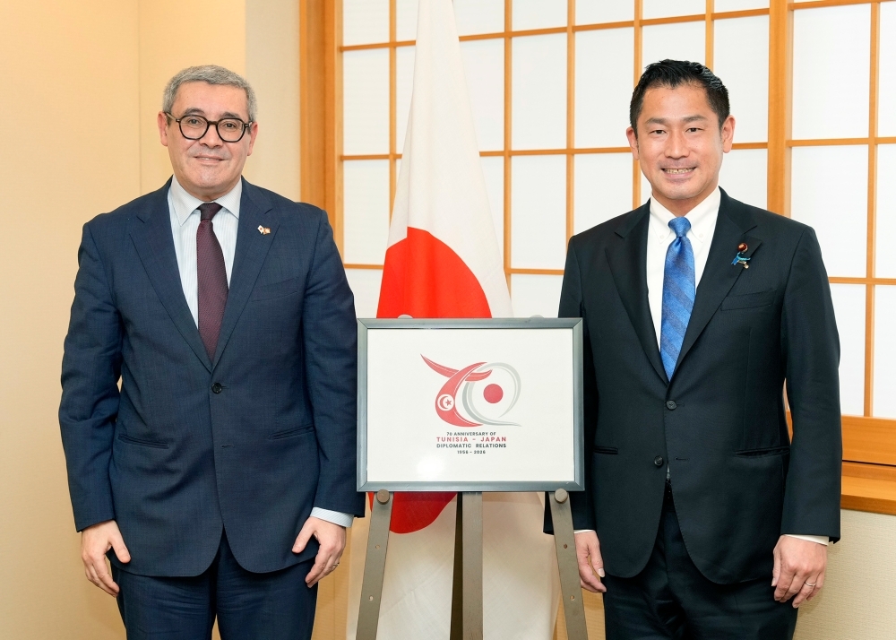 Parliamentary Vice-Minister ONISHI and H.E. Mr. Chafra, Ambassador of Tunisia, posing for a photo with a logo commemorating the 70th anniversary of the establishment of diplomatic relations in between