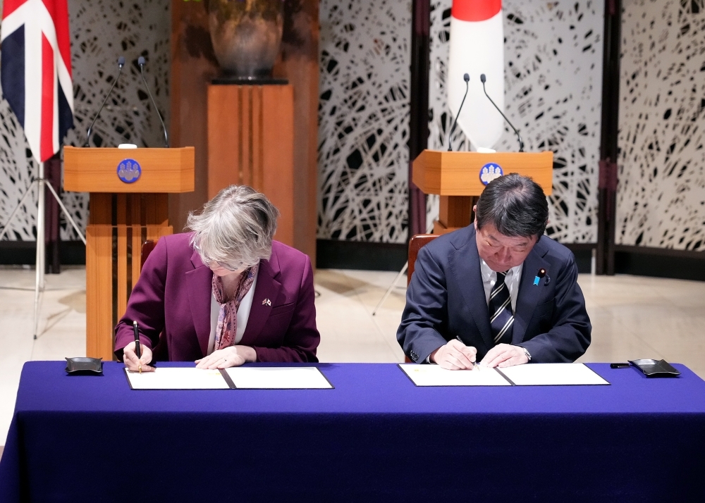 Minister MOTEGI and Foreign Secretary Cooper signing the Japan-UK Memorandum