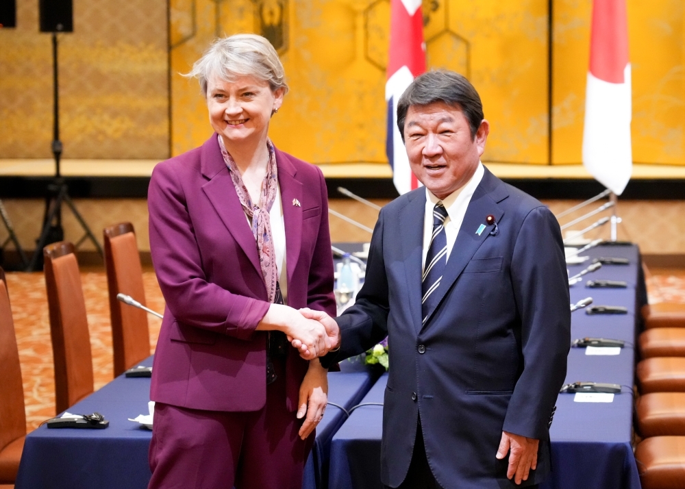 Minister MOTEGI shaking hands with Foreign Secretary Cooper