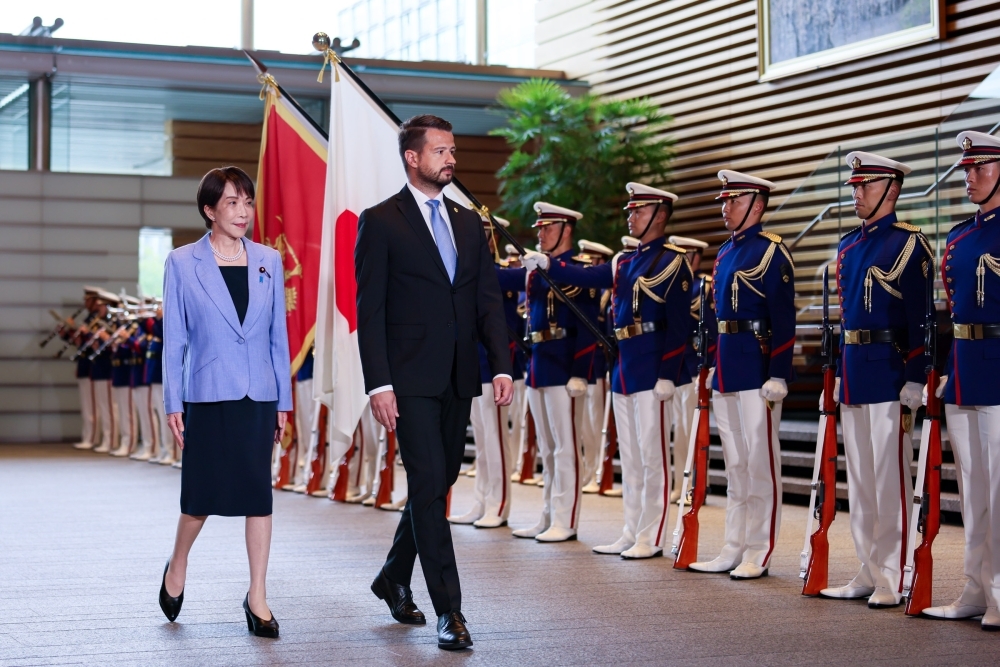 Prime Minister Takaichi  walking before the honor guard with President Milatović 