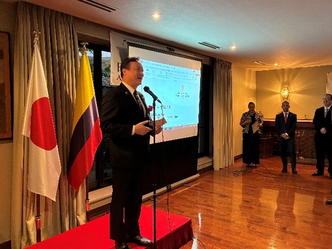 State Minister Horii delivering his speech in front of national flags of Japan and Colombia