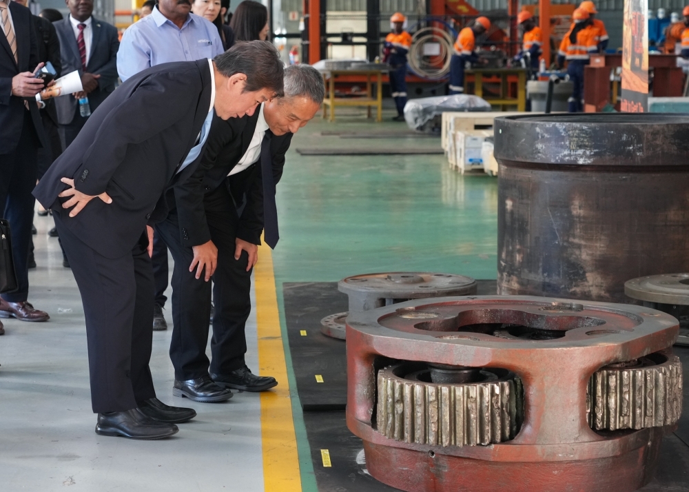 Foreign Minister Motegi looking at some parts hearing explanation of the company's staff