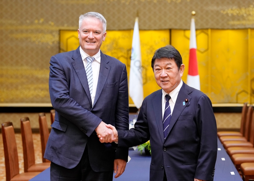 Foreign Minister MOTEGI shaking hands with OECD Secretary-General Cormann