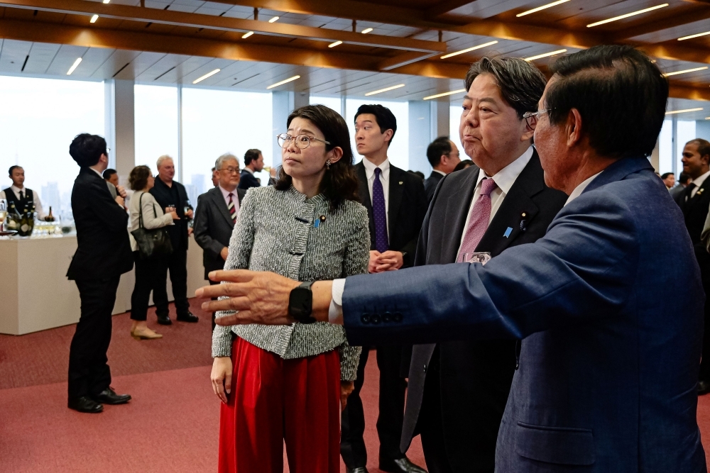 State Minister Kunimitsu and Minister of Internal Affairs and Communications Hayashi listen to an explanation