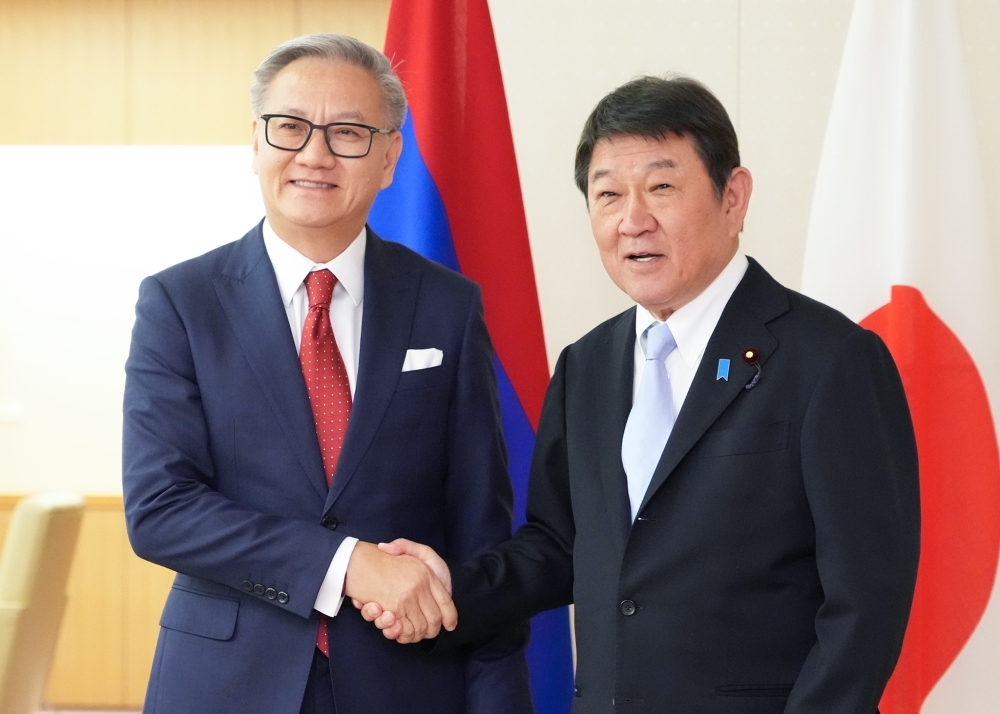 Foreign Minister MOTEGI shaking hands with H.E. Mr. PHOMVIHANE, Deputy Prime Minister and Minister of Foreign Affairs of Laos
