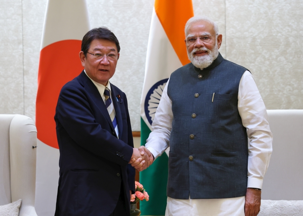 Minister MOTEGI taking photo, shaking hands with H.E. Mr. Narendra Modi, Prime Minister of India