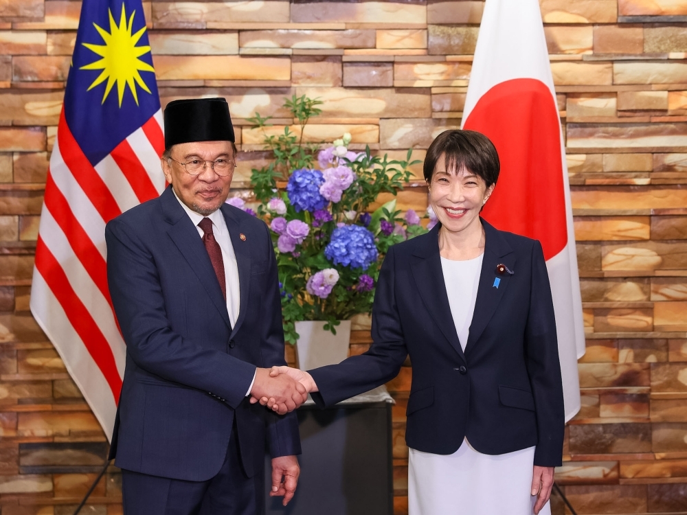 Prime Minister TAKAICHI shaking hands with H.E. Dato' Seri Anwar, Prime Minister of Malaysia