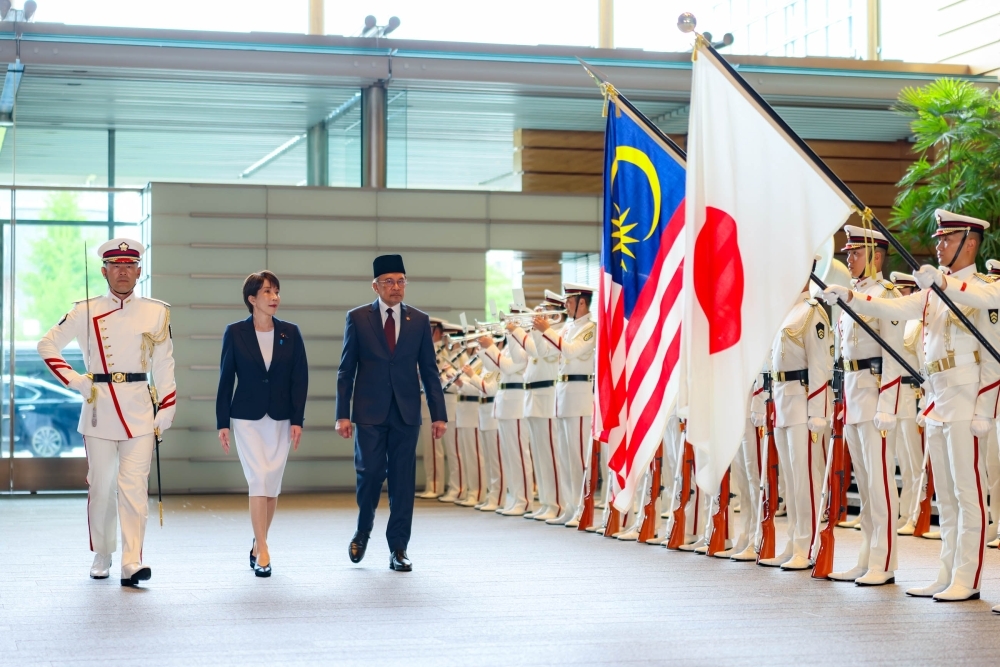 Prime Minister TAKAICHI and H.E. Dato' Seri Anwar, Prime Minister of Malaysia, walking in front of the honor guard