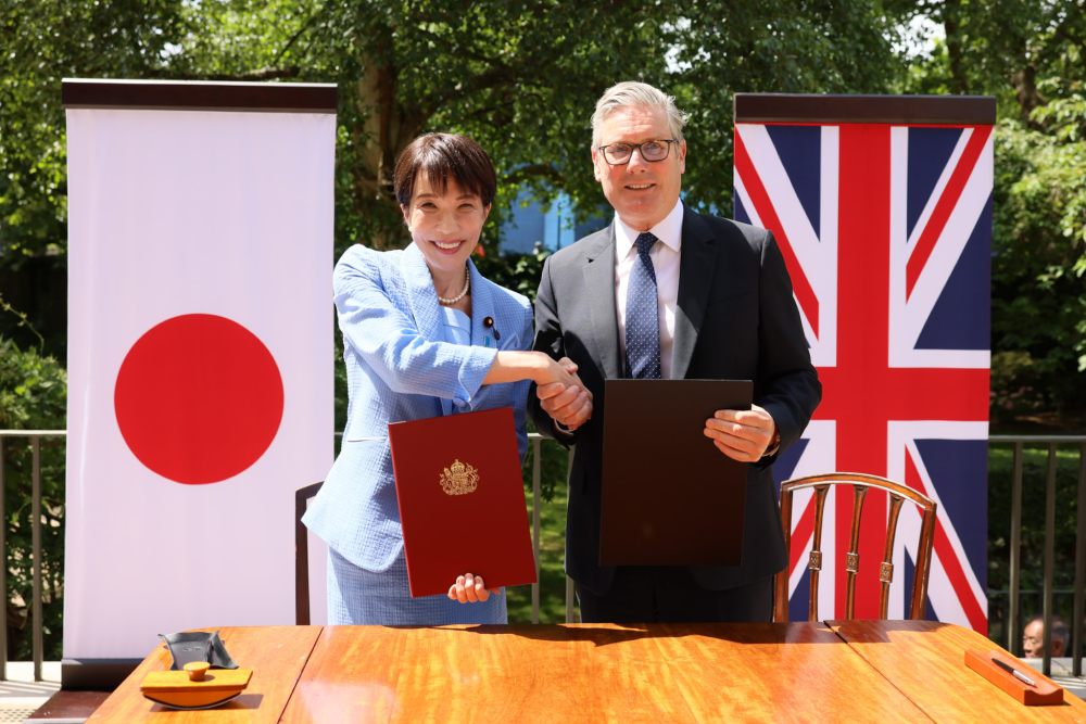 Prime Minister TAKAICHI and Prime Minister Starmer shaking hands after signing and exchanging a Memorandum of Cooperation