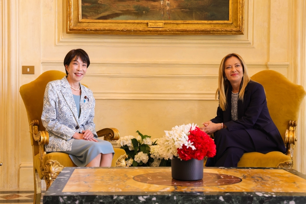 Prime Minister TAKAICHI and Prime Minister Meloni sitting across from each other on golden sofas, smiling during their Japan-Italy summit meeting