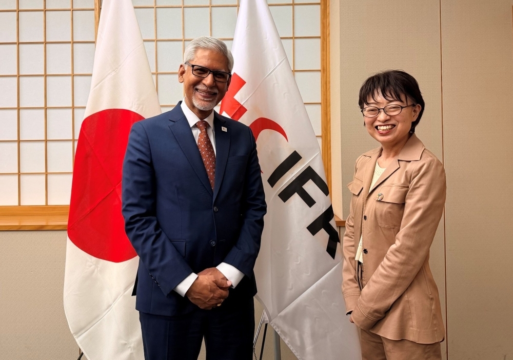 Ms. NISHIZAKI, Ambassadorfor Humanitarian Assistance of the Ministry of Foreign Affairs, and Mr. Jagan Chapagain, Secretary General of the IFRC, posing for a photograph in front of the Japanese national flag and the IFRC flag