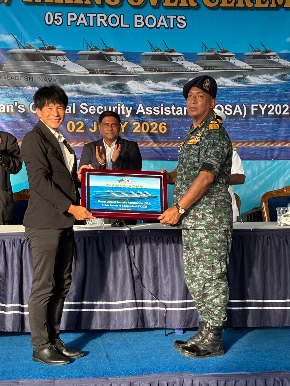 Parliamentary Vice-Minister SHIMADA handing a framed picture of a patrol boat to Adviser Shamsul