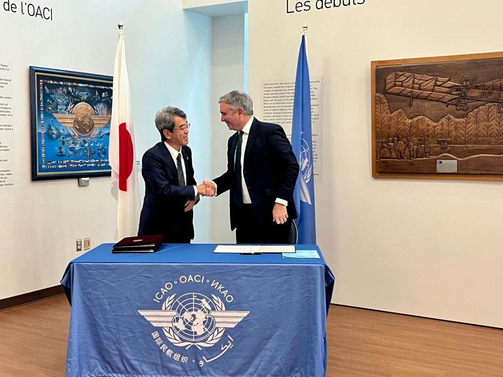 Japanese official and ICAO official are shaking hands.