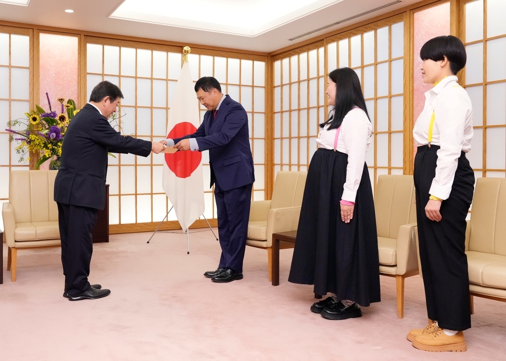 Foreign Minister MOTEGI presenting letters of appointment to comedian Mr. TONIKAKU